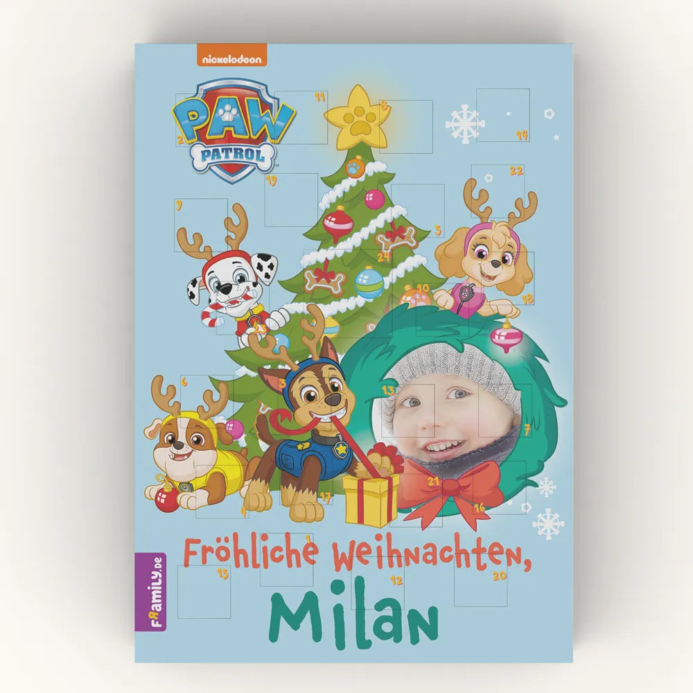 Der personalisierte Adventskalender zeigt das Foto eines Jungens mit der Paw Patrol vor einem geschmückten Tannenbaum und dem Titel "Fröhliche Weihnachten, Milan".