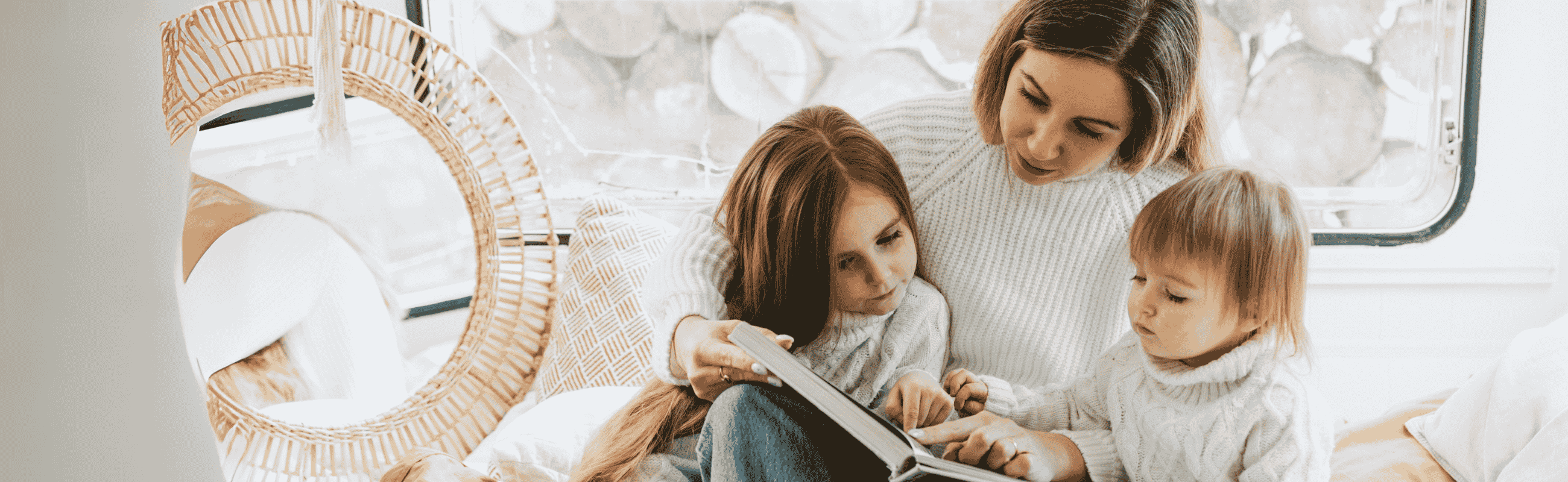 Mama liest mit ihren Kindern ein Buch