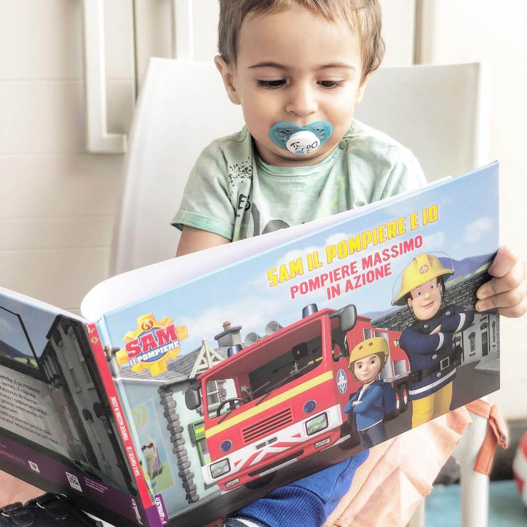 Kleiner Junge liest Feuerwehrmann Sam Buch