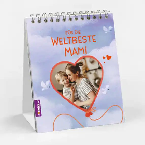 Der spiralgebundene Tischkalender "Für die weltbeste Mama" von Framily zeigt auf dem Cover ein herzförmiges Foto einer lächelnden Frau, die ein Kind umarmt, mit blauen und lila Schmetterlingen - ein einzigartiges, perfektes Geschenk für Mama.