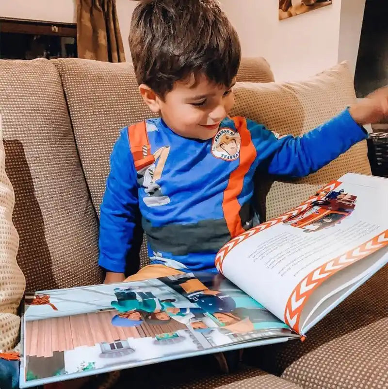 Kleiner Junge liest personalisierts Feuerwehrmann Sam Buch