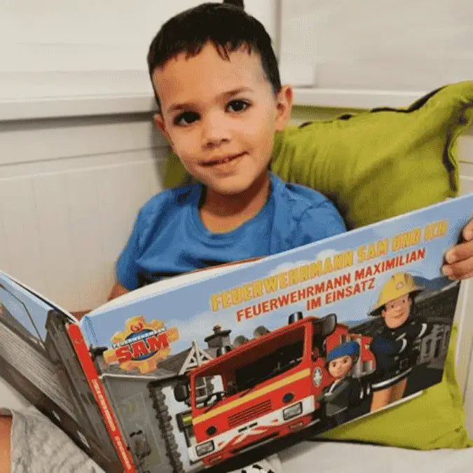 Ein Junge sieht sich ein Feuerwehrmann Sam Buch an