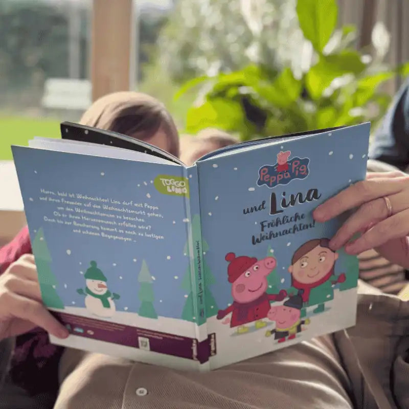 Großvater liest seinem Enkel aus einem Peppa Buch vor