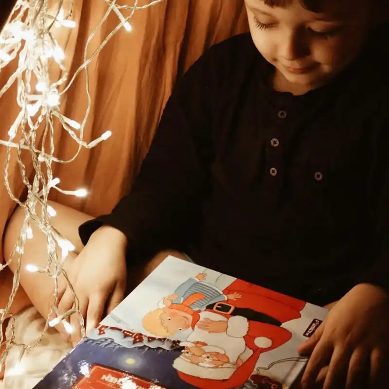 Ein Kind hält das Buch Weihnachtsmärchen in der Hand