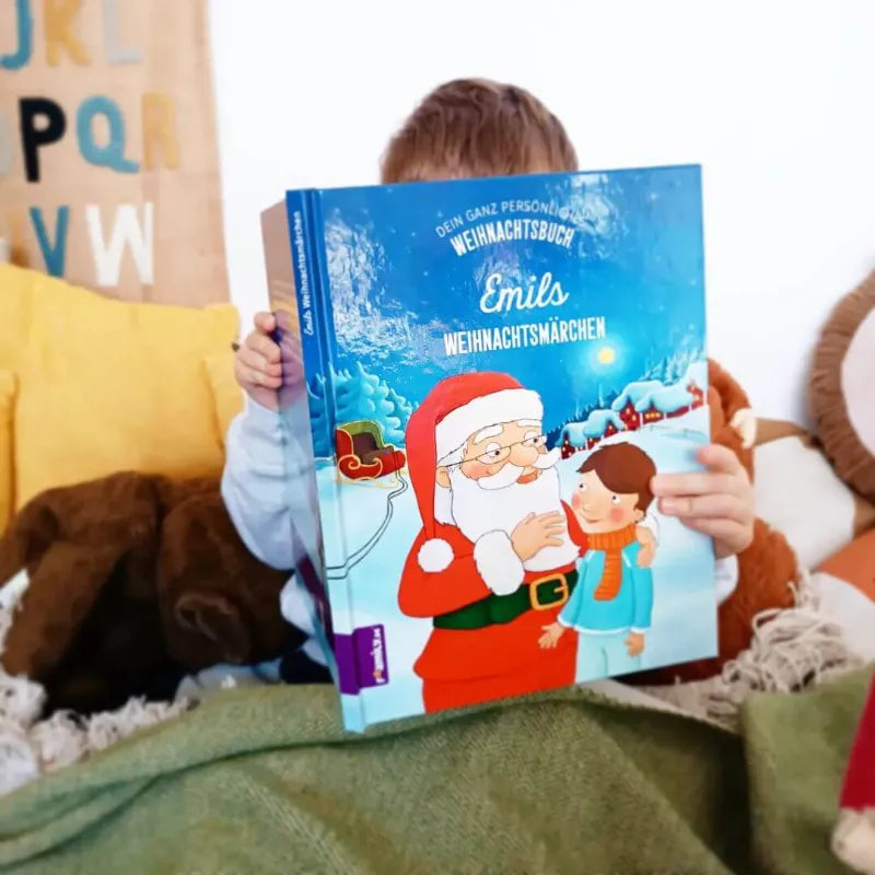 Ein Kind hält das Buch Weihnachtsmärchen in der Hand und liest