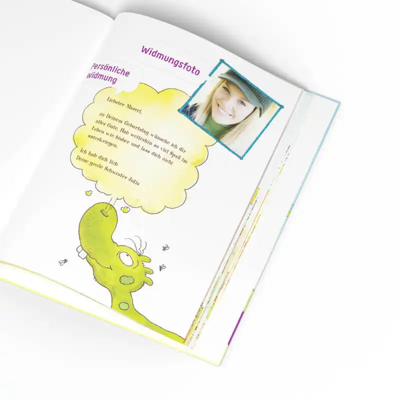 Ein aufgeschlagenes Buch zeigt einen grünen Olchis-Dinosaurier, der in einer gelben Blase denkt. Darüber befindet sich ein kleines Foto einer blonden Frau und deutsche Texte wie "Widmungsfoto" und "persönliche Widmung". "Die Olchis und du" von Framily ist perfekt für jede Kinderbuchsammlung.